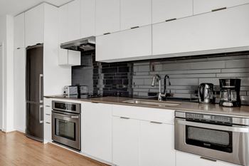 A kitchen with white cabinets and stainless steel appliances